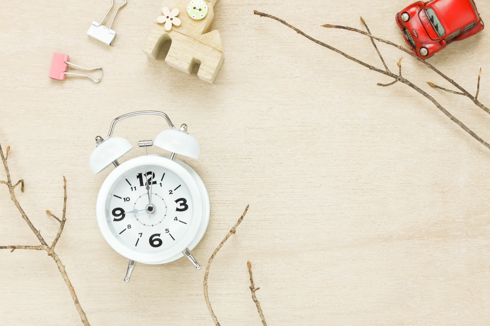 Reloj junto a casa decorativa sobre fondo de madera